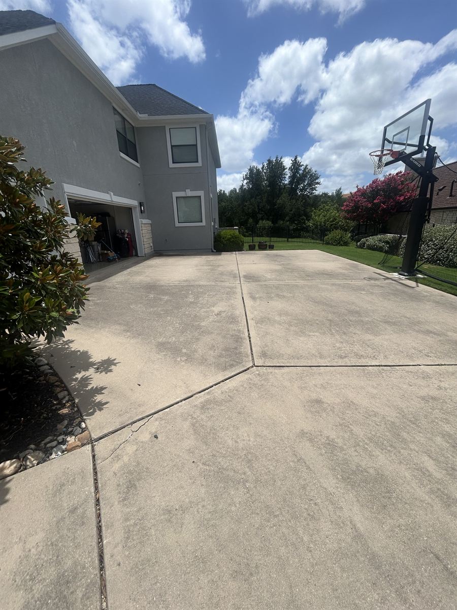 Backyard concrete sport court with dirt and staining before cleaning
